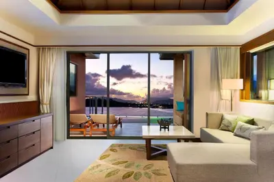 a living room with a large window with a view of the ocean at The Westin Siray Bay Resort & Spa, Phuket in Phuket Town