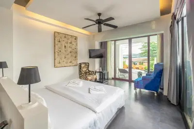 a hotel room with a bed and a balcony at See Sea Villa Phuket SHA in Patong Beach