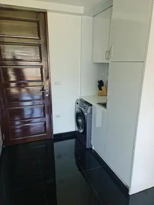 a kitchen with a washing machine and a door at Art Patong Residence in Patong Beach