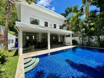 a swimming pool in front of a house at Miguel Villa by G Estate in Nai Harn Beach