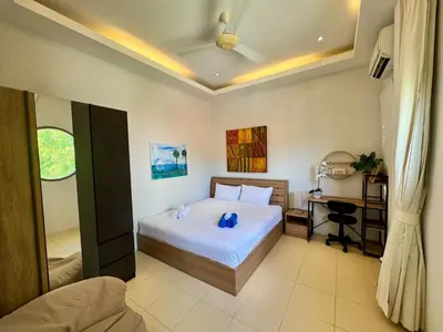 a bedroom with a bed and a desk in it at Miguel Villa by G Estate in Nai Harn Beach