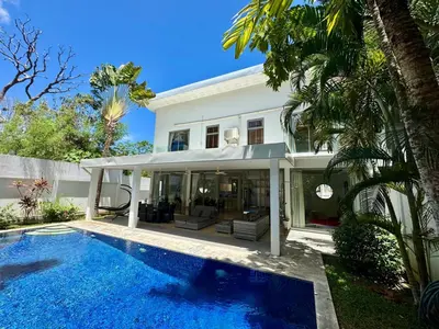 a villa with a swimming pool in front of a house at Miguel Villa by G Estate in Nai Harn Beach