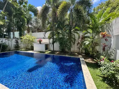 a swimming pool in a yard with palm trees at Miguel Villa by G Estate in Nai Harn Beach