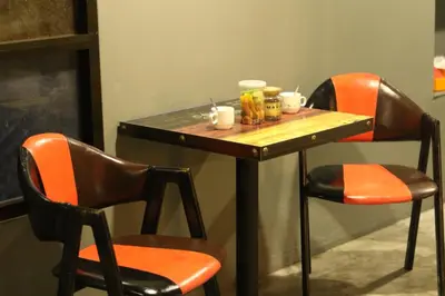 a table with two chairs and a table with cups on it at Baan Paea Guest House in Ban Ket Ho