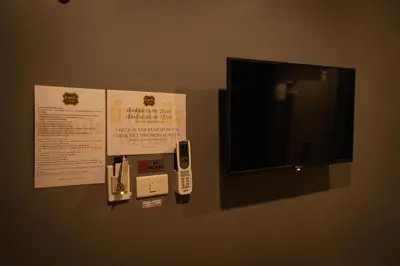 a wall with a tv and a cell phone on it at Baan Paea Guest House in Ban Ket Ho