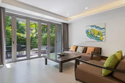 a living room with a couch and a table at Nai Thon Beachfront Apartments in Nai Thon Beach