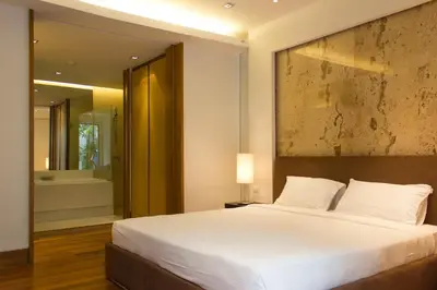 a bedroom with a large white bed and a bathroom at Nai Thon Beachfront Apartments in Nai Thon Beach
