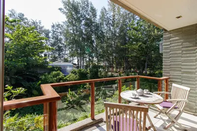 a patio with a table and chairs on a balcony at Nai Thon Beachfront Apartments in Nai Thon Beach