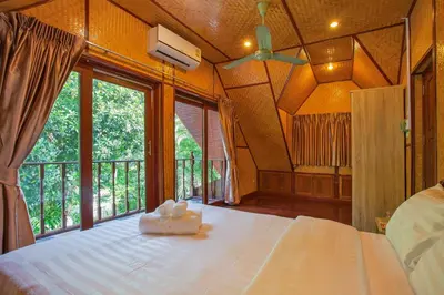 a bedroom with a large bed with a large window at Traditional Thai Villa Nikkie in Tropical Nature, 4BR & Pool, near Rawai Beach in Nai Harn Beach