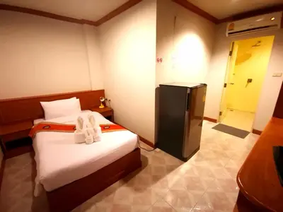 a small room with a bed and a refrigerator at Casa Jip Guesthouse in Patong Beach