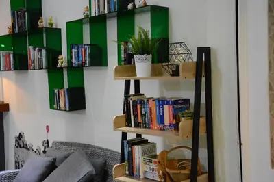 a living room with bookshelves filled with books at Casa Jip Guesthouse in Patong Beach