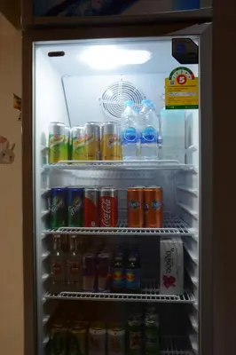 an open refrigerator filled with drinks and sodas at Casa Jip Guesthouse in Patong Beach