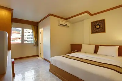 a bedroom with a large bed and a window at Casa Jip Guesthouse in Patong Beach