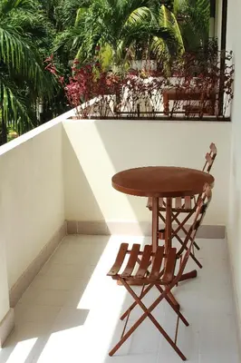 a wooden table and a chair on a balcony at Patong Palace Hotel - SHA Extra Plus in Patong Beach