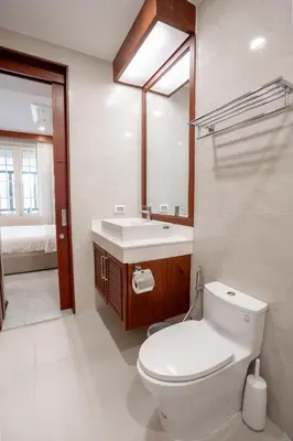 a bathroom with a toilet and a sink and a mirror at Q Kata Residence in Kata Beach