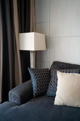 a room with a bed with a lamp and pillows at Q Kata Residence in Kata Beach