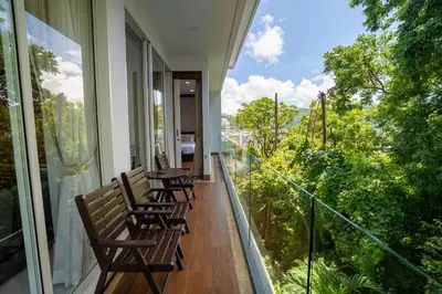 a balcony with chairs and a table on it at Q Kata Residence in Kata Beach