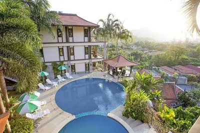 a hotel with a swimming pool in front of a building at Kamala Villa Hill in Kamala Beach