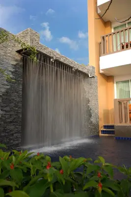 a waterfall is coming out of a building at Princess Seaview Resort & Spa - SHA Plus in Karon Beach