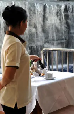 a woman standing next to a table with a plate of food at Princess Seaview Resort & Spa - SHA Plus in Karon Beach