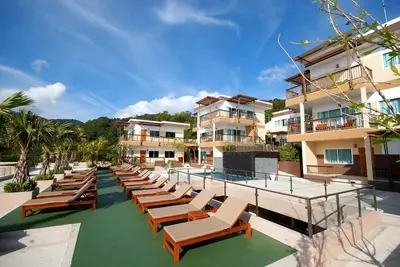 a row of lounge chairs on the side of a building at Princess Seaview Resort & Spa - SHA Plus in Karon Beach