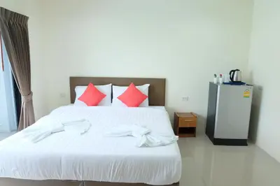 a bedroom with a large white bed with red pillows at DOS'S HOUSE in Nai Yang Beach