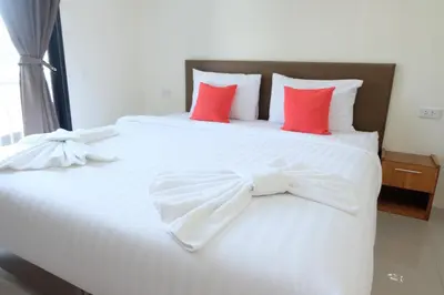 a white bed with red pillows in a room at DOS'S HOUSE in Nai Yang Beach