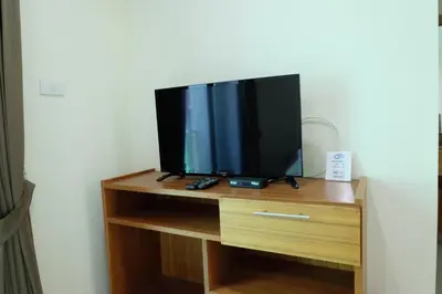 a flat screen tv sitting on top of a wooden entertainment center at DOS'S HOUSE in Nai Yang Beach
