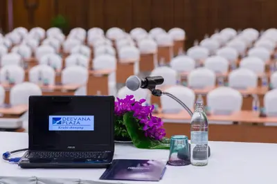 a laptop computer sitting on a table with a microphone at Deevana Plaza Krabi Aonang in Ao Nang Beach