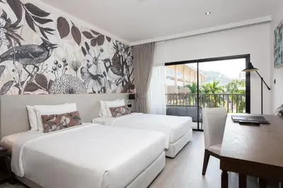 a hotel room with two beds and a desk and a desk at Deevana Plaza Krabi Aonang in Ao Nang Beach