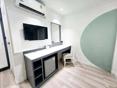 a living room with a tv and a desk with a fireplace at SEATEL Phuket, Patong Beach in Patong Beach