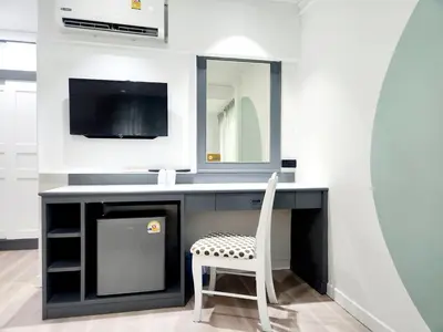 a bathroom with a desk with a chair and a tv at SEATEL Phuket, Patong Beach in Patong Beach