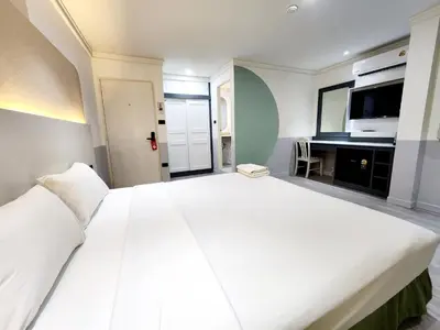 a large white bed in a room with a tv at SEATEL Phuket, Patong Beach in Patong Beach