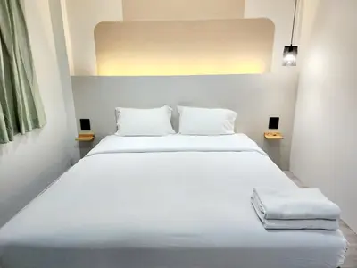 a bedroom with a large white bed with two pillows at SEATEL Phuket, Patong Beach in Patong Beach
