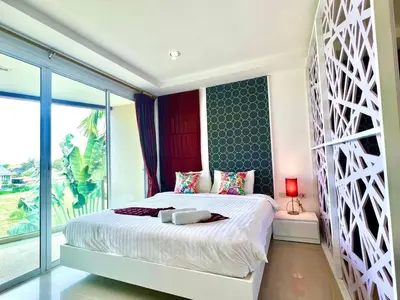 a bedroom with a large bed and a large window at Sivana Place Phuket in Bang Tao Beach