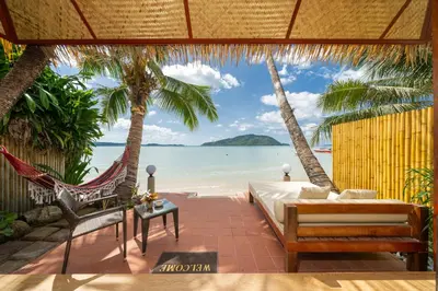 a bedroom with a bed and a hammock on the beach at Friendship Beach Resort & Atmanjai Wellness Centre in Rawai Beach