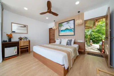 a bedroom with a large bed and a window at Friendship Beach Resort & Atmanjai Wellness Centre in Rawai Beach