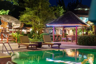 a resort with a pool and chairs and a gazebo at Friendship Beach Resort & Atmanjai Wellness Centre in Rawai Beach