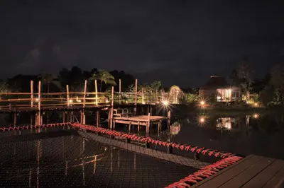 a dock with a table in the water at night at Awana Villa Resort Yaonoi - SHA Extra Plus in Ko Yao Noi