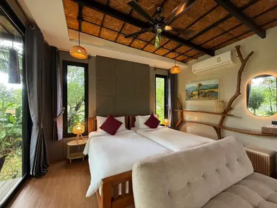 a bedroom with a large bed and a couch at Awana Villa Resort Yaonoi - SHA Extra Plus in Ko Yao Noi
