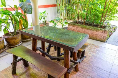 a wooden table and a bench and some plants at Chez Charly Bungalow in Nai Yang Beach