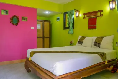 a bedroom with a large bed with colorful walls at Chez Charly Bungalow in Nai Yang Beach
