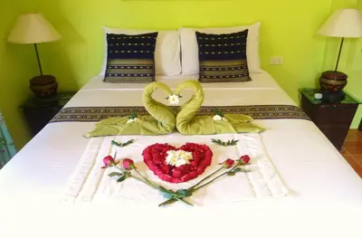 a bed with two hearts and flowers on it at Chez Charly Bungalow in Nai Yang Beach