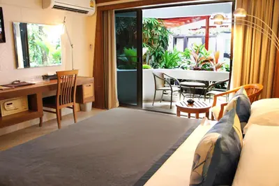a living room with a couch and a desk and a table at Safari Beach Hotel Patong in Patong Beach