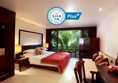 a hotel room with a bed and a sign that reads shea plus at Safari Beach Hotel Patong in Patong Beach