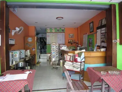 a restaurant with orange walls and tables and chairs at Seaworld Guesthouse in Ao Nang Beach