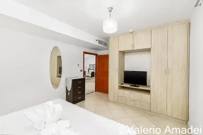 a bedroom with a bed and a tv in a room at KB Apartments Karon Beach by PHR in Karon Beach