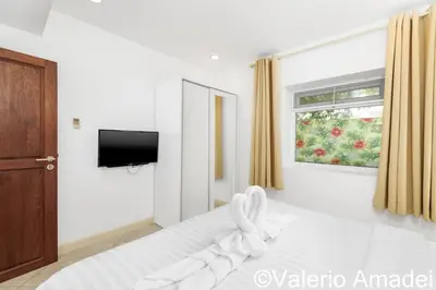 a bedroom with a white bed and a window at KB Apartments Karon Beach by PHR in Karon Beach