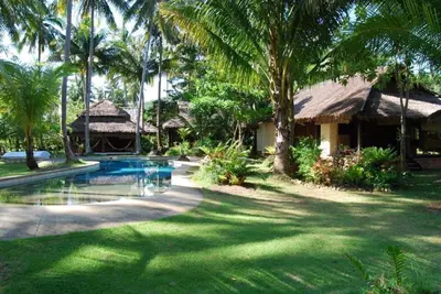 a resort with a swimming pool and palm trees at Koyao Bay Pavilions - Beach Resort and Pool Villas in Ko Yao Noi