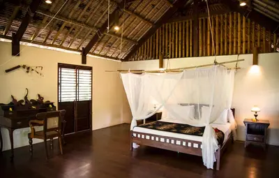 a bedroom with a bed with a canopy and a desk at Koyao Bay Pavilions - Beach Resort and Pool Villas in Ko Yao Noi